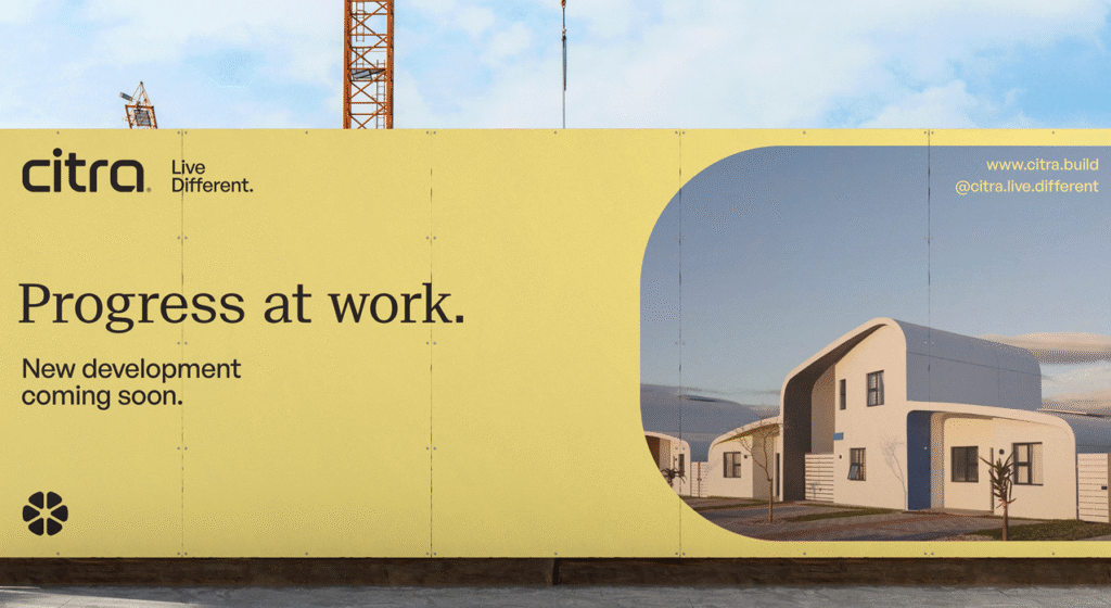 Construction hoarding in Citra’s new signature yellow featuring the logo, emblem, and eHomes imagery with the text "Progress at work. New development coming soon.