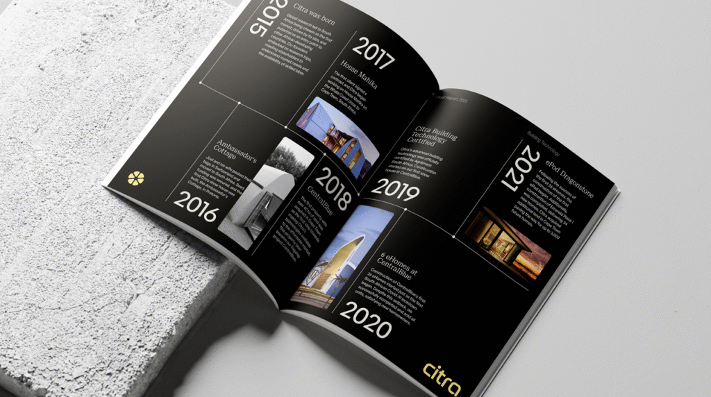 An open brand book featuring a double-page spread of Citra’s timeline, accompanied by architectural photography and the new emblem.