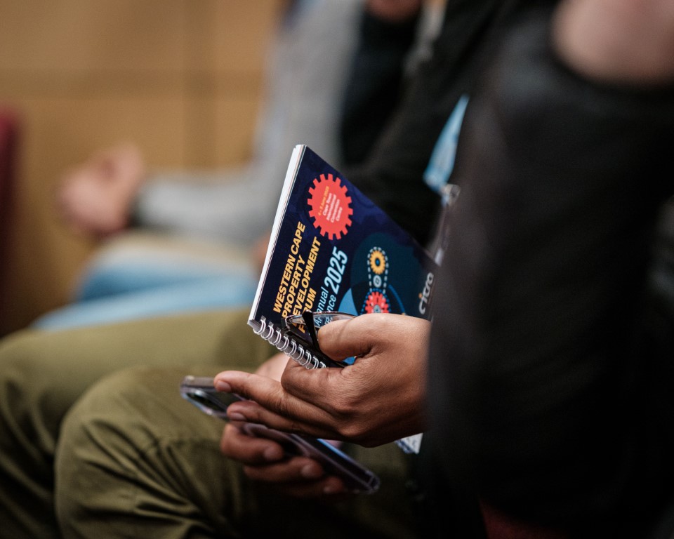 View of the WCPDF Official Conference Booklet cover, held in a man's hands at the event.