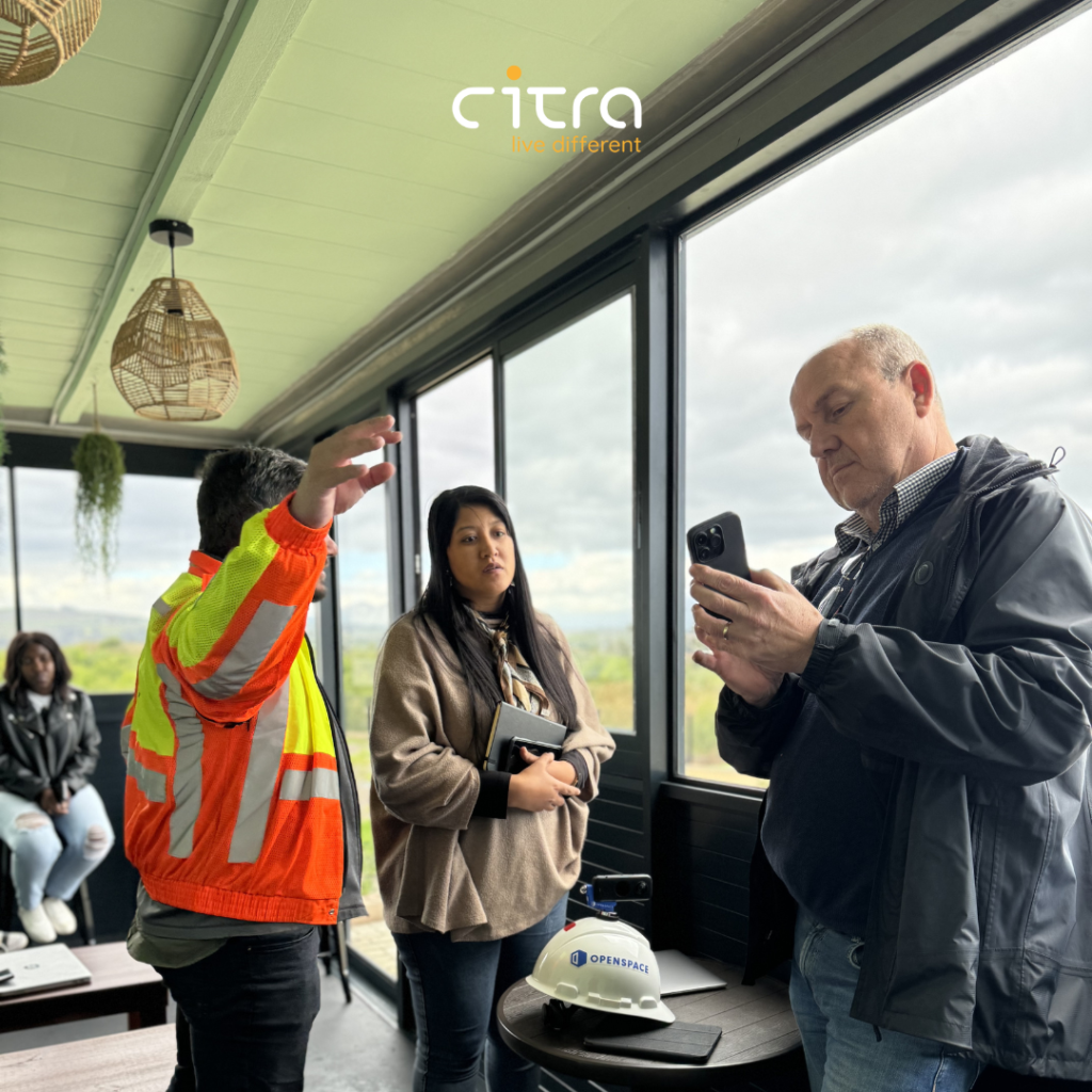 Citra Head of Construction, Citra Customer Care Manager and Open Space Trainer looking at the Open Space App on a phone during the Open Space Training.