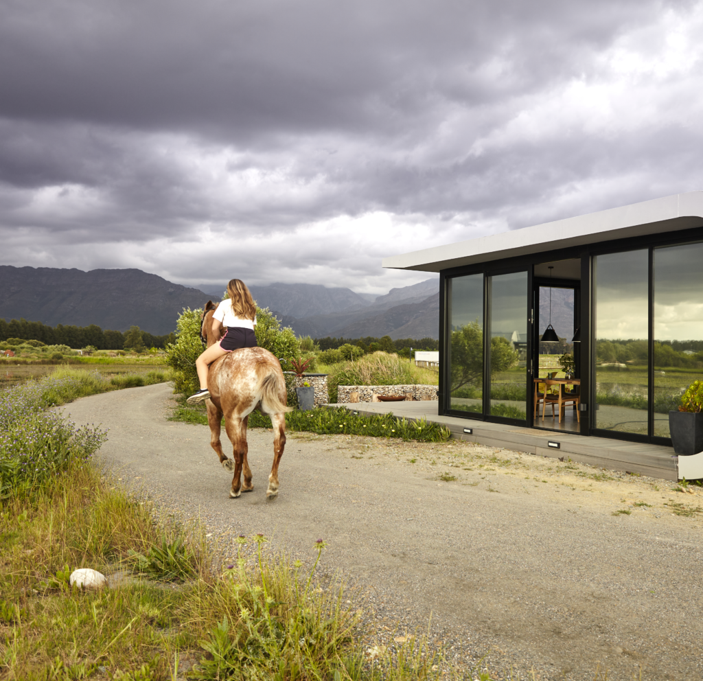 A girl rides a horse into the distance, with a Citra ePod nearby, against a backdrop of stunning grey clouds filling the sky.