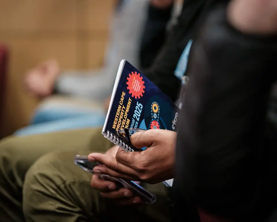 View of the WCPDF Official Conference Booklet cover, held in a man's hands at the event.