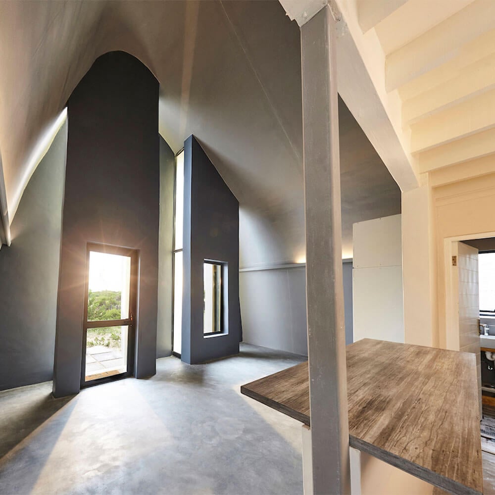Spacious modern interior featuring high ceilings, large windows, and sleek design elements in a cont.