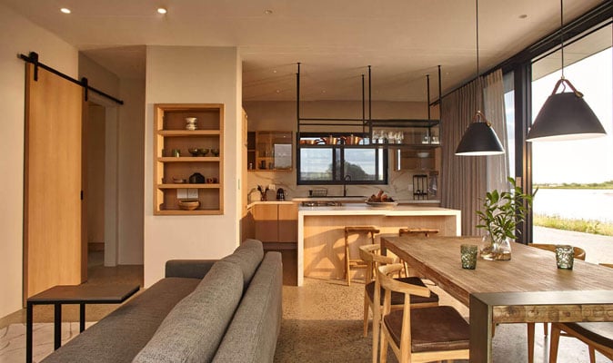 Stylish open-concept living and dining space featuring natural light, wooden furniture, and modern d.