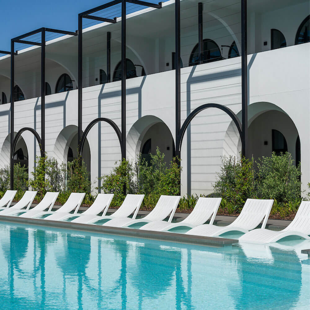 Luxurious poolside lounge area with white sunbeds and modern architecture at Citra resort.