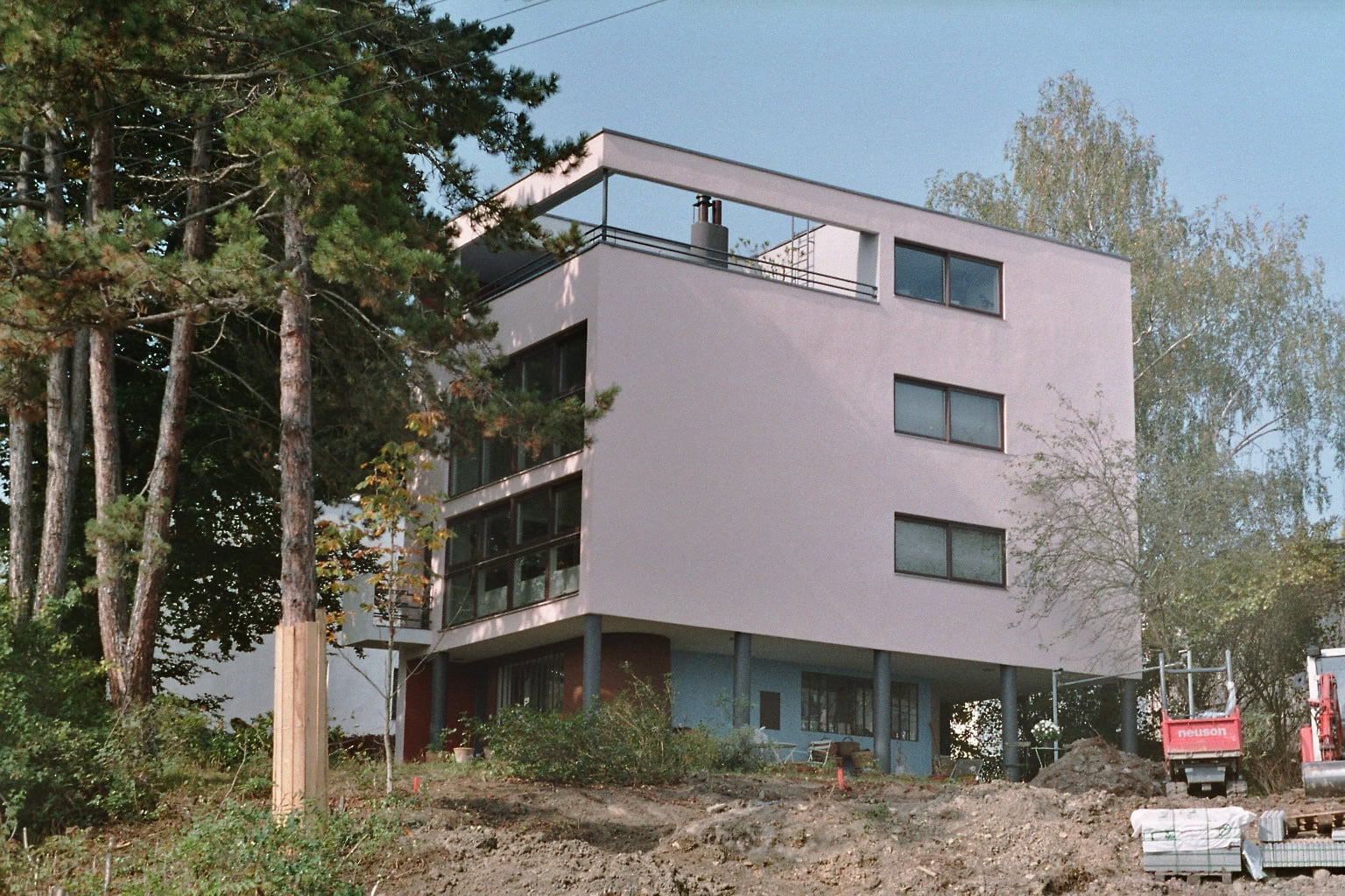 Modern minimalist residential building with large windows and outdoor terrace.