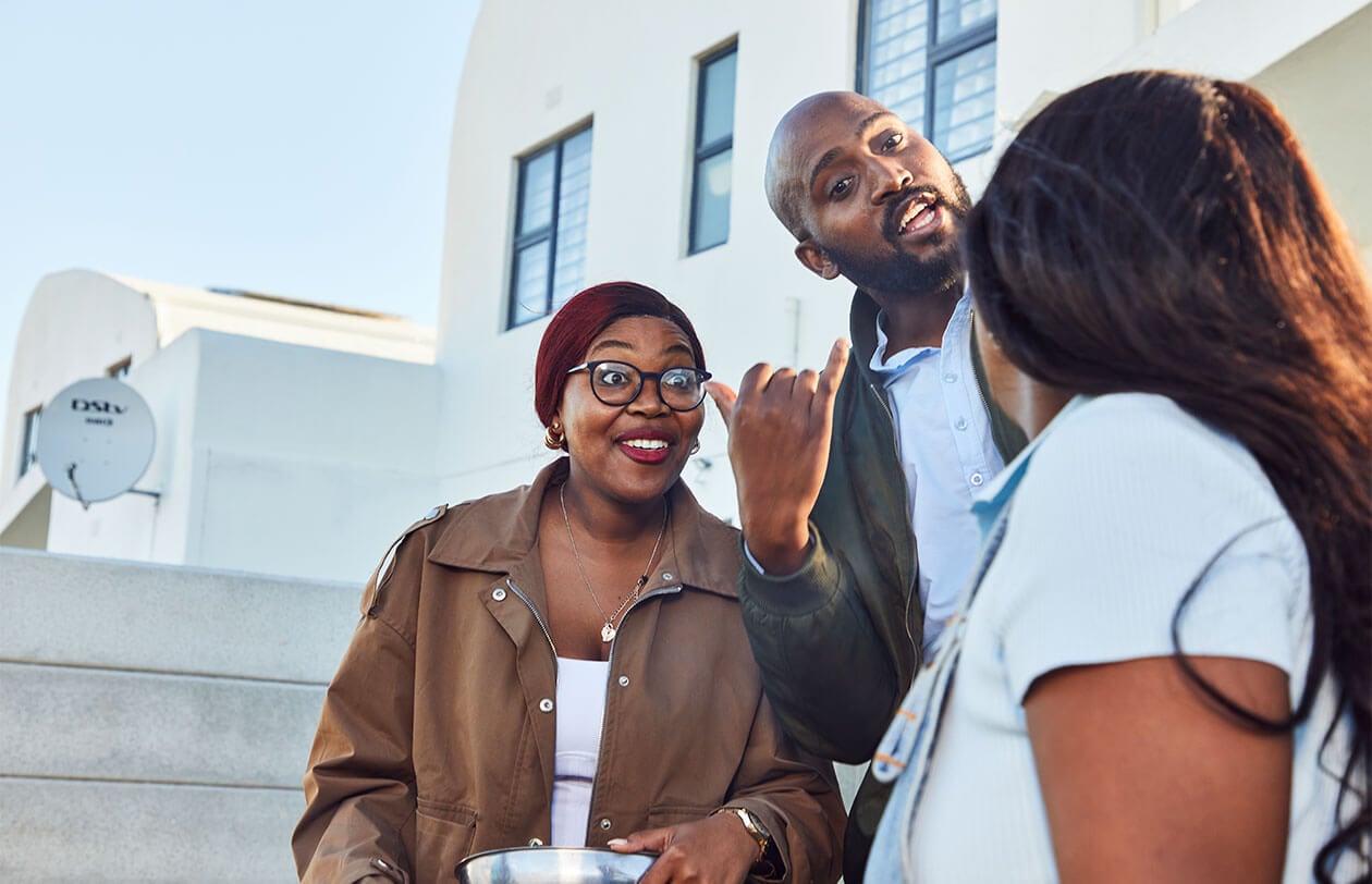 Diverse group of professionals engaging in a discussion outdoors in front of a modern building.
