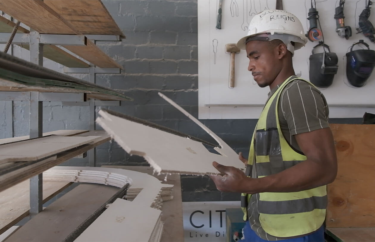 Construction worker in safety gear inspecting building materials at Citra.