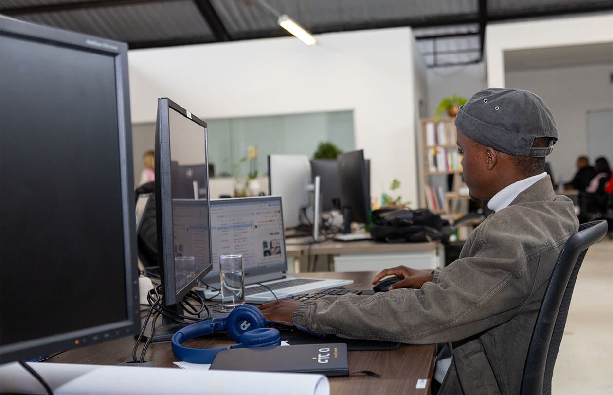 Office worker focused on computer screen in a contemporary workspace environment.