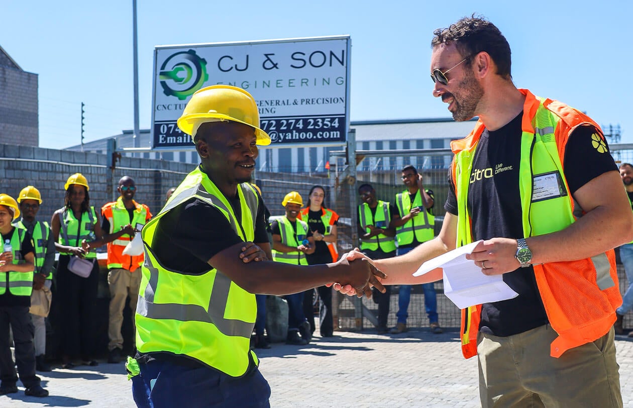 Construction workers shaking hands at a site, team collaboration, safety gear, and professional envi.