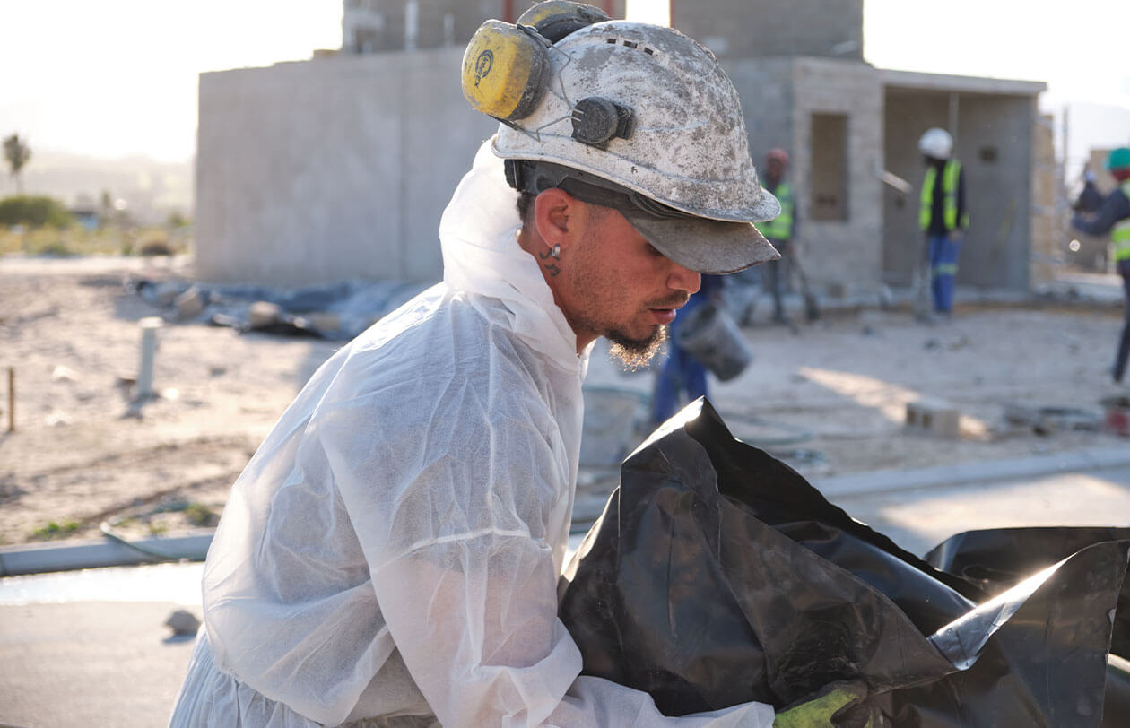 Deep Dive Construction worker inspecting materials on a building site in Citra development.