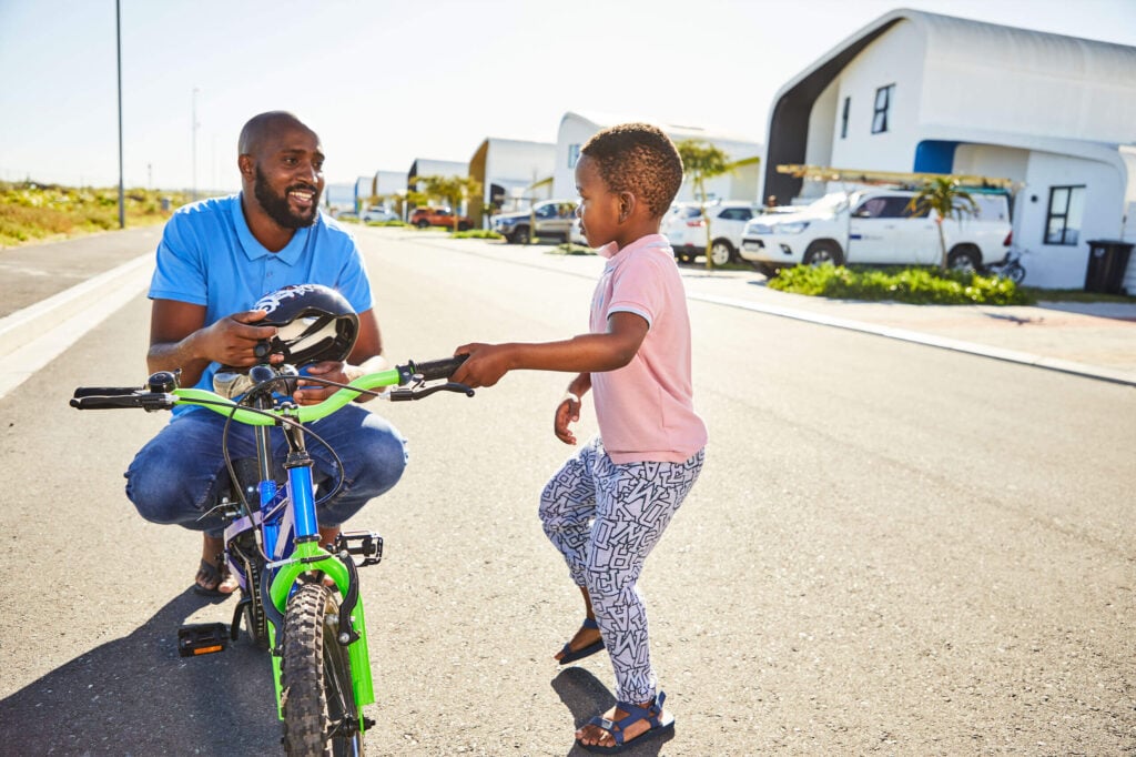 father teaching son to ride bicycle 1