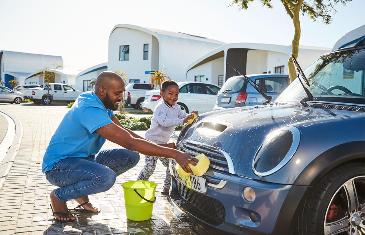 Man washing a car at a car wash station in South Africa.