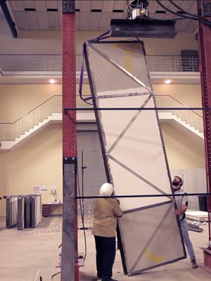 During a strength test, two men carefully maneuver a Citra Building Technology panel into position, as another colleague observes the process.